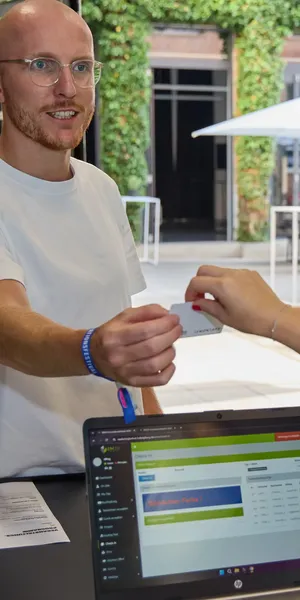 Übergabe eine PVC Badge an Gast beim Check-In