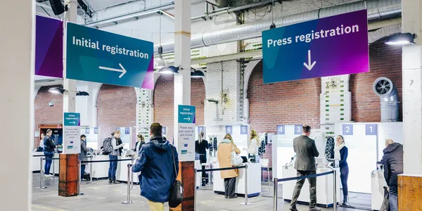 Blick auf Check-In Counter einer Veranstaltung mit Beschilderung